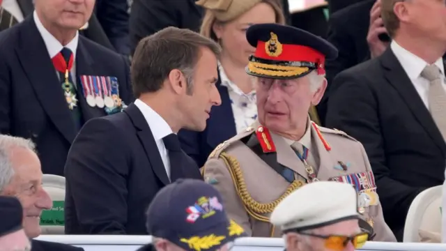 King Charles III speaks with President of France Emmanuel Macron during the UK national commemorative event for the 80th anniversary of D-Day, held at the British Normandy Memorial in Ver-sur-Mer, Normandy, France. Picture date: Thursday June 6, 2024