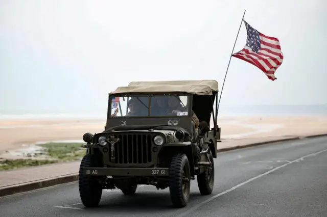 World War II reenactors drive a Willys Jeep ahead of the 80th anniversary of the 1944 D-Day landings in Vierville-sur-Mer above Omaha Beach, Normandy region, France, June 1, 2024.