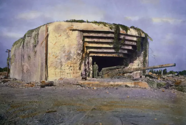 A US soldier stands by a knocked out Nazi battery near Utah Beach