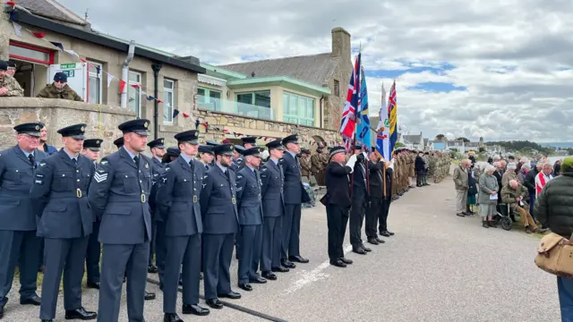Military service personnel stand in rows