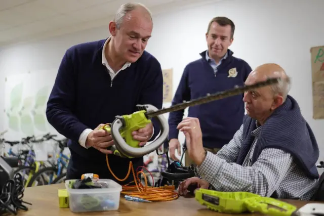 Ed Davey with a hedge-trimmer