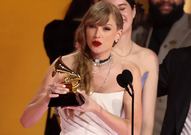 Taylor Swift accepting album of the year at  the Grammy Awards in 2024.