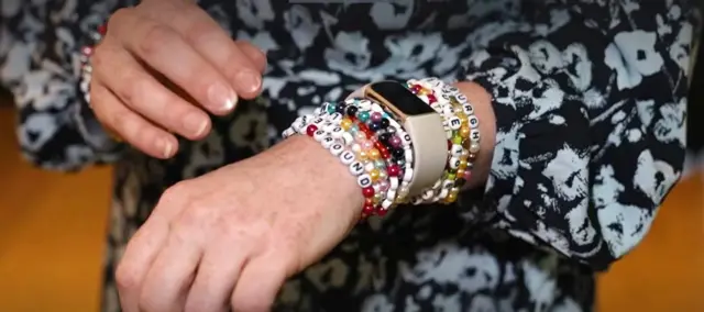 Close up of a Shirley-Anne Somerville's hands, showing a row of bracelets on her wrist