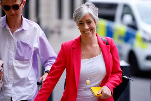 Daisy Cooper carrying a yellow phone case