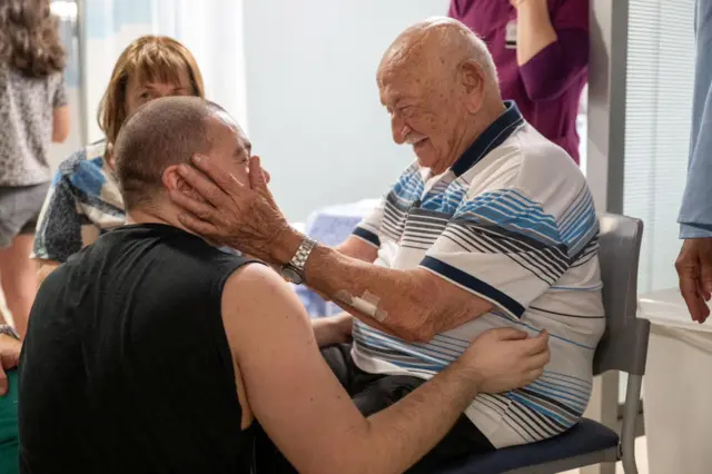 Almog Meir Jan is greeted by a loved one - an elderly man on a chair