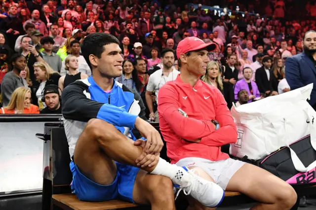 Carlos Alcaraz sitting next to Rafael Nadal