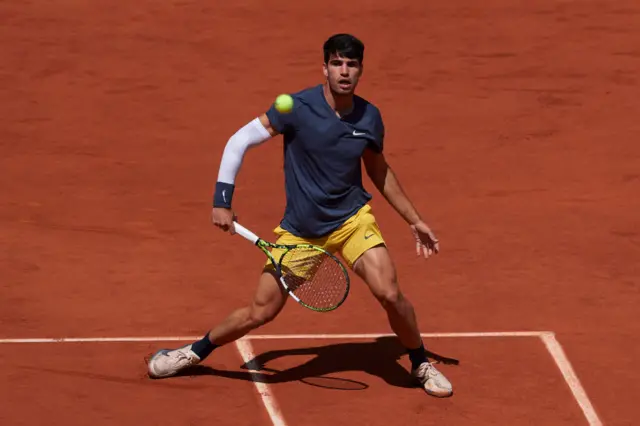 Carlos Alcaraz hitting a backhand