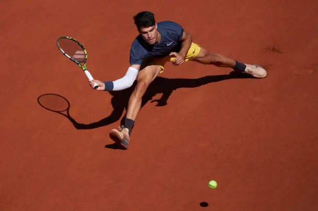 Carlos Alcaraz sliding into a forehand