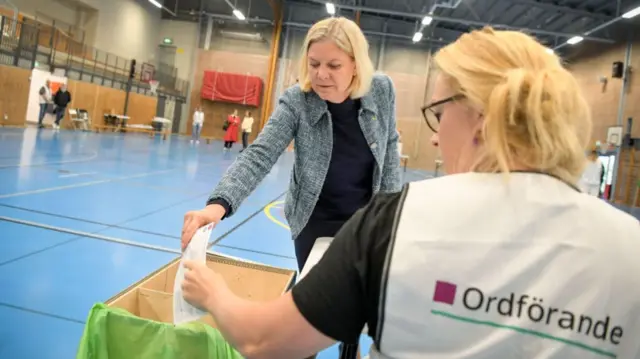 The leader of Sweden's social democratic party and former Prime Minister of Sweden Magdalena Andersson (L) casts her ballot for European Parliament Elections at a polling station in Stockholm