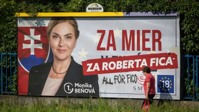 European election poster in Slovakia: "For peace, for Robert Fico": A woman walks past an election banner in Bratislava, Slovakia, on 8 June 2024. Voters in Slovakia are casting the ballots in European Parliamentary elections just weeks after an attempt to assassinate populist Prime Minister Robert Fico.