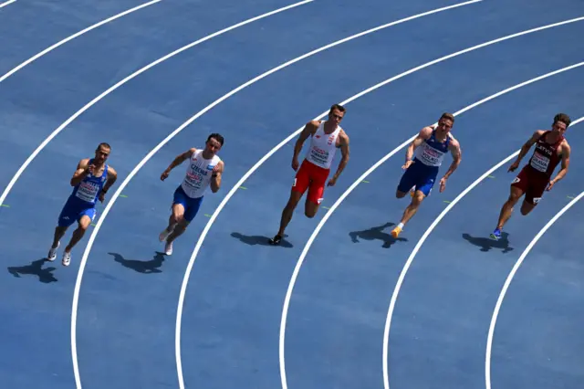 Athletes complete in the men's 200m heats