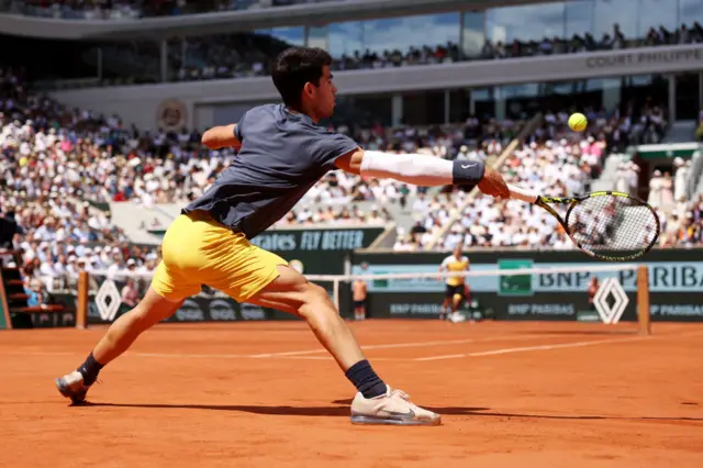 Carlos Alcaraz sliding for a forehand