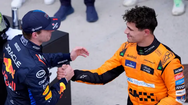 Lando Norris (R) shaking hands with Max Verstappen (L)