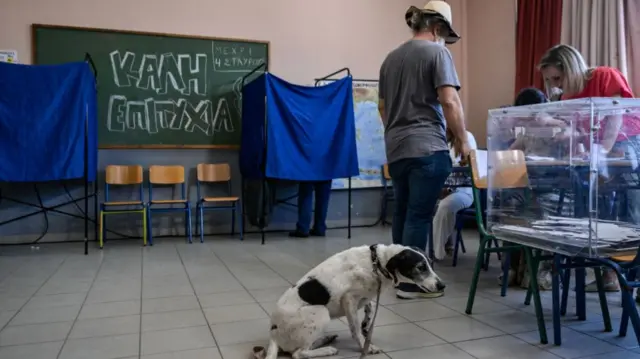 Voters cast their ballot in a polling station during the European elections in Athens on June 9, 2024. Voting began across Europe on June 9, 2024