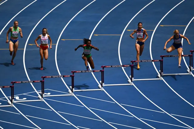 Athletes compete in the heats of the women's 400m hurdles