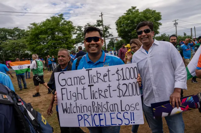 An India fan with a poster saying game ticket $1000, flight ticket $2000 that says "Watching Pakistan lose Priceless!!"