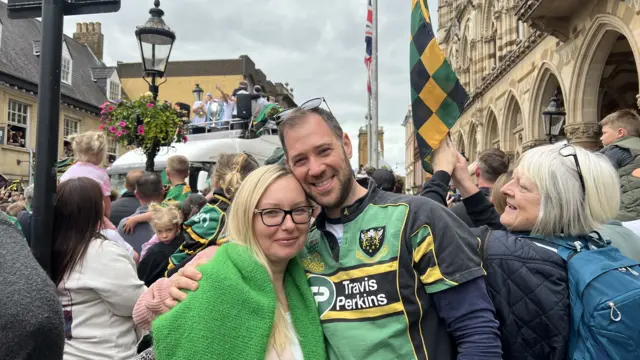 Aleksandra Malecka and Ben Francis hug each other amidst the celebrating Saints fans