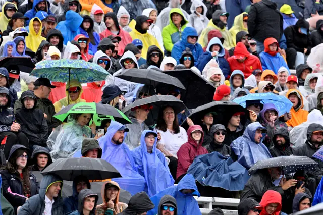 Fans in the stands at Circuit Gilles Villeneuve sheltering under umbrellas