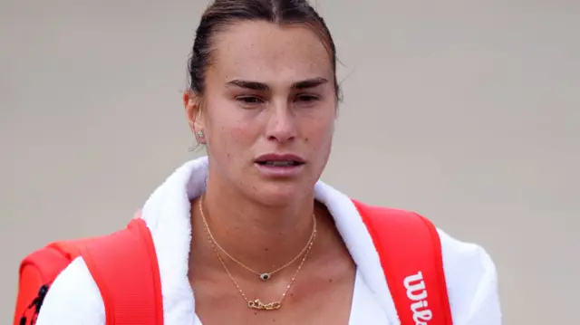 Aryna Sabalenka walks to a practice session at Wimbledon