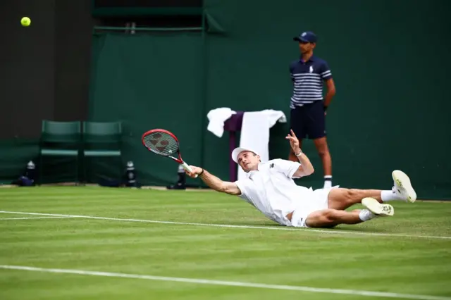 Tommy Paul reacts after hitting a ball lying on the floor