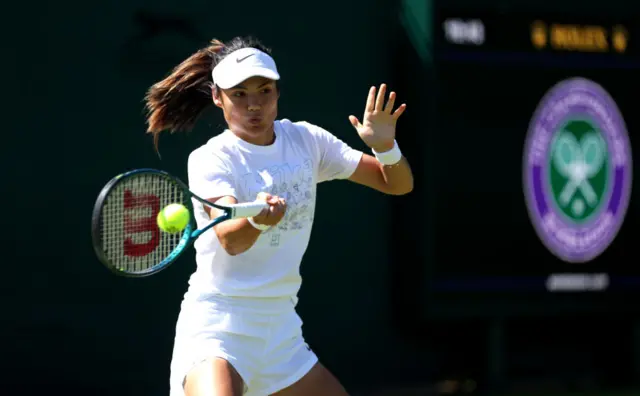 Emma Raducanu hits a tennis ball with her racquet