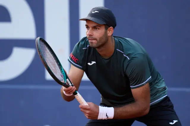 Facundo Diaz Acosta holds a tennis racquet