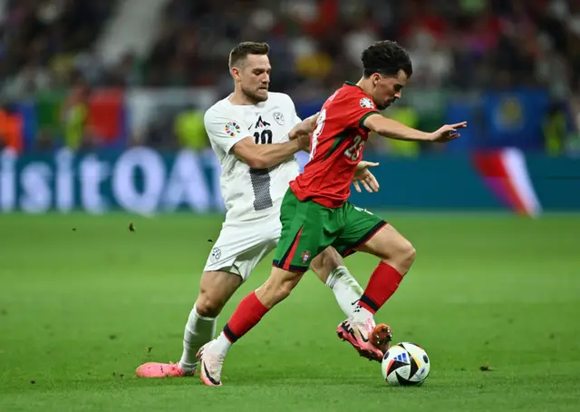 Vitinha of Portugal runs with the ball whilst under pressure from Timi Max Elsnik of Slovenia