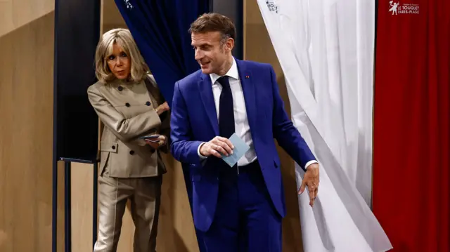 Macron and his wife coming out of the polling booths