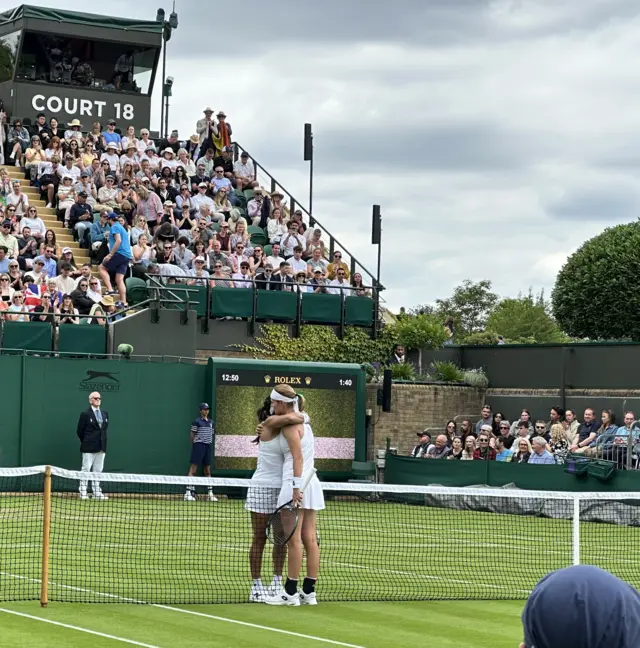 Heather Watson and Greet Minnen hug at the net