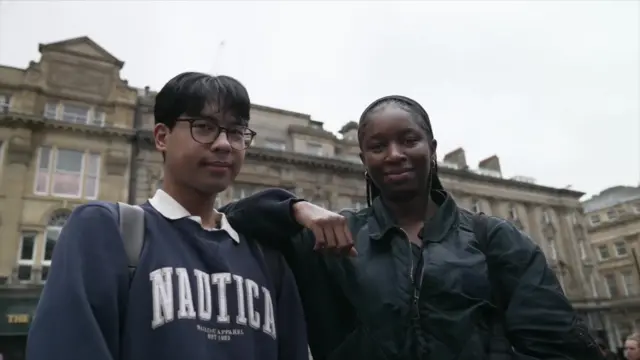 A young male and female standing side by side