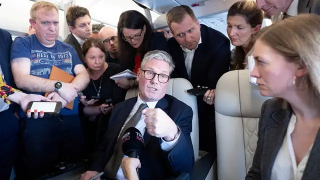 Starmer surrounded by photographers on the plane