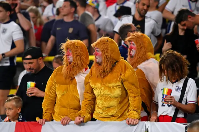 Three England fans in lion suits