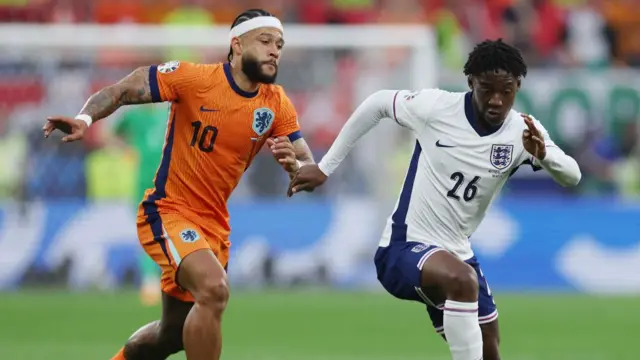 Kobbie Mainoo of England runs with the ball under pressure from Memphis Depay of the Netherlands during the UEFA EURO 2024 semi-final match between Netherlands and England at Football Stadium Dortmund on July 10, 2024 in Dortmund, Germany.