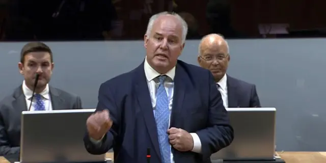 Andrew RT Davies wears a blue suit and tie while he speaks in the Senedd