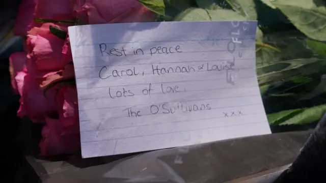 A card that reads "“Rest in peace Carol, Hannah and Louise, lots of love The O'Sullivans""