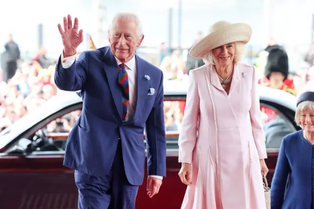 King Charles and Queen Camilla wave as they walk into the Senedd