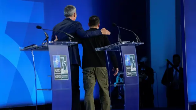 Ukraine's President Volodymyr Zelenskiy and NATO Secretary General Jens Stoltenberg leave the stage