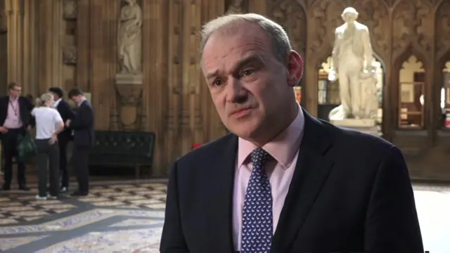 Headshot of Ed Davey as he speaks to meda