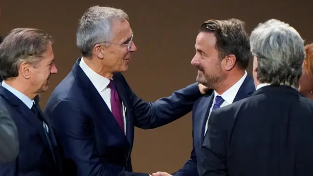 Jens Stoltenberg shakes hands with Luxembourg's Deputy Prime Minister Xavier Bettel