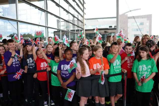 A group of children wearing purple, red and green t-shirts