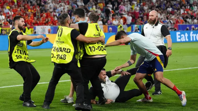 A Euro 2024 security guard slips into Alvaro Morata as Spain celebrate their semi-final win over France