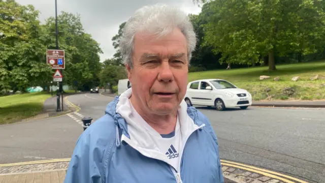 Joe Eastlake. He has light grey hair and is wearing a blue jacket and white Adidas top.