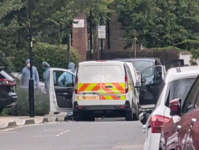 Forensic officers coming out of police vans