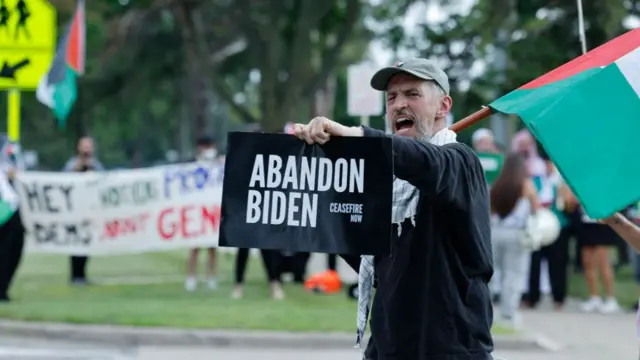 Voters hold an 'abandon Biden' sign