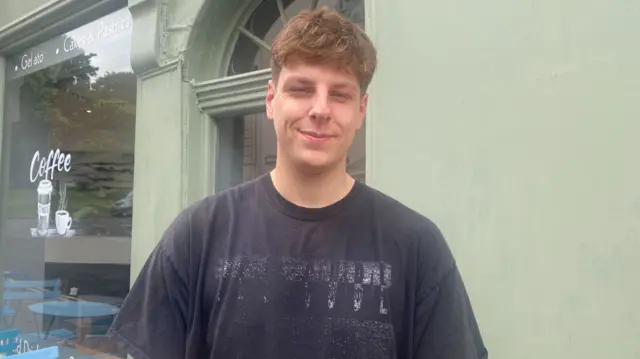 Joey Hemming. He has short, light brown hair and is wearing a black t-shirt. He is looking directly at the camera and smiling.