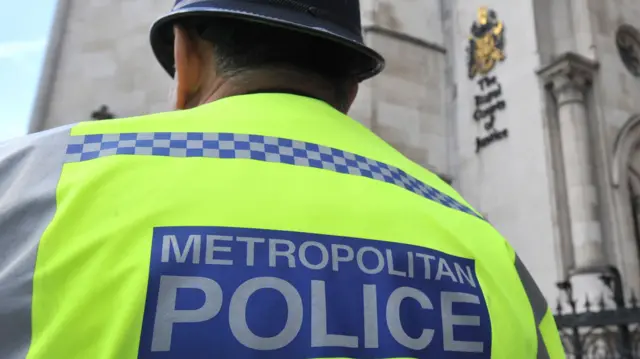 Metropolitan Police officer outside the Royal Courts of Justice in central London