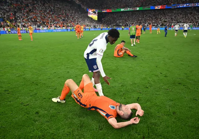 Stefan de Vrij of the Netherlands looks dejected after the team's defeat as he is consoled by Kobbie Mainoo of England