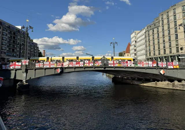 England flags hang over the side of a bridge