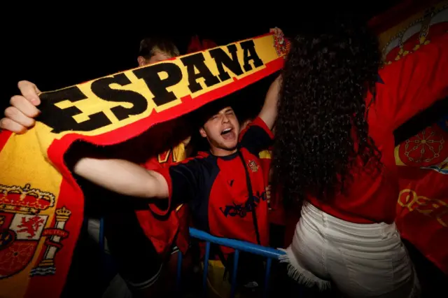 Spain fan holds aloft a country-themed scarf