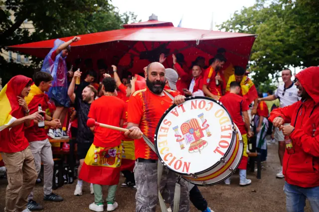 Spanish fan bangs a drum